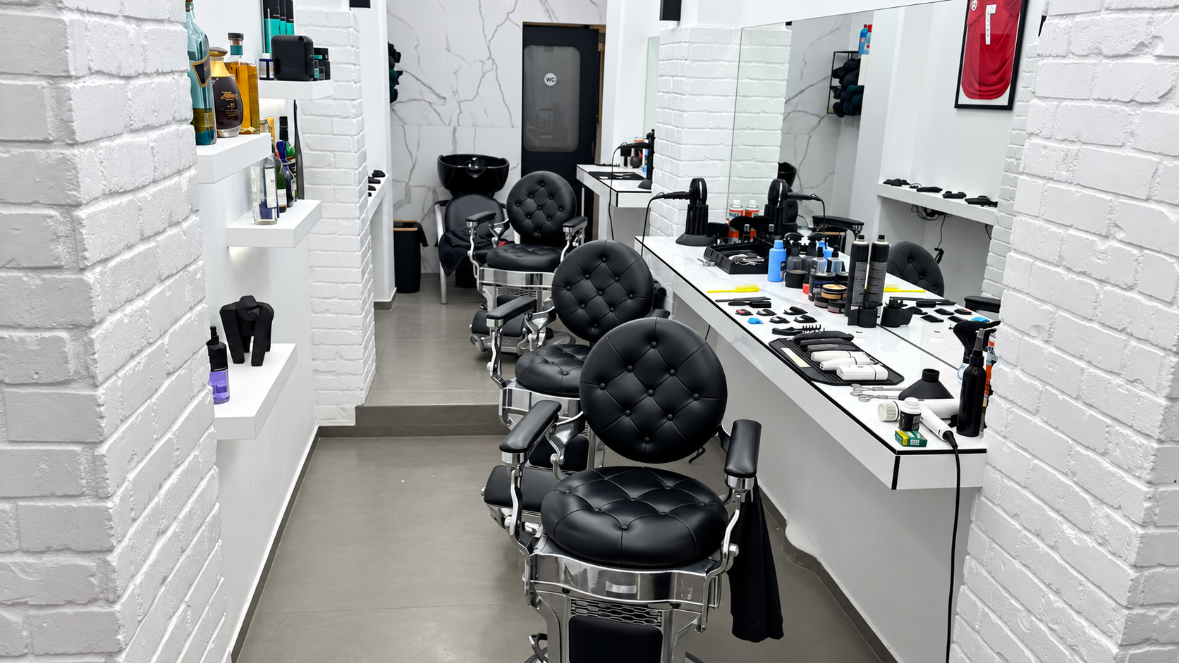 Row of black leather barber chairs inside Ghost Barber Club